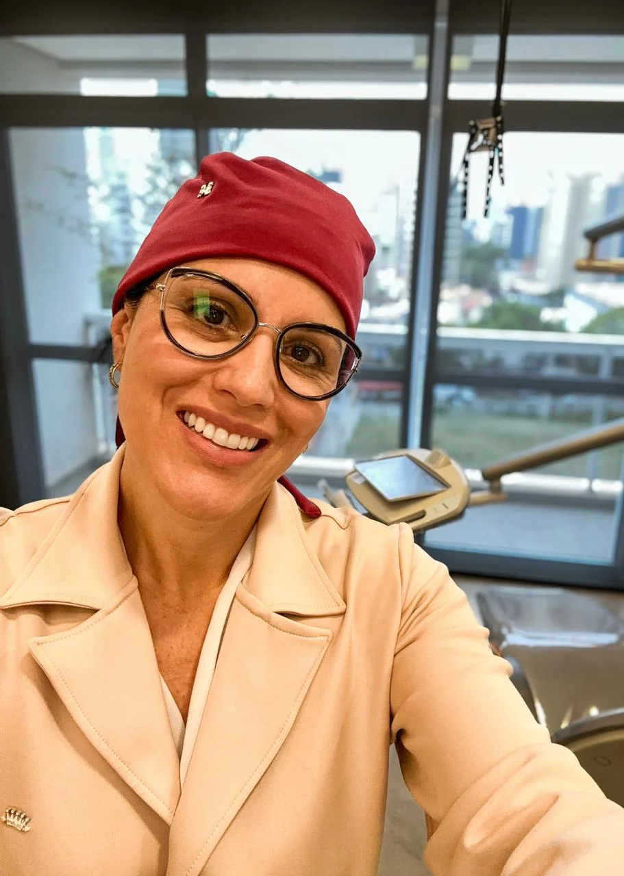 Dra. Roberta sorrindo, de touca e jaleco, pronta para atender