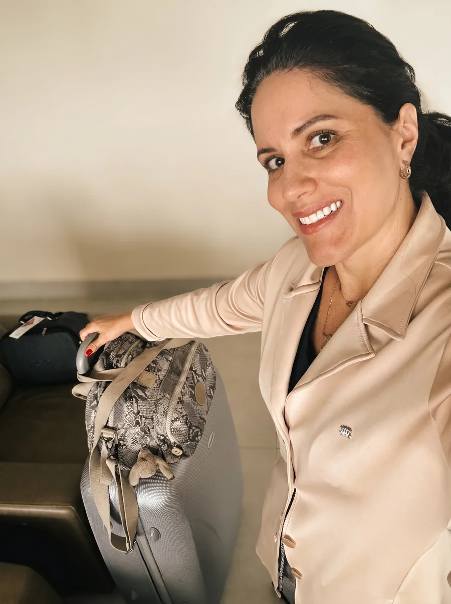 Dra. Roberta sorrindo ao lado das maletas de equipamento, pronta para sair para um atendimento